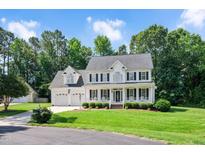 Charming two-story home with a well-manicured lawn and a classic white porch at 1605 Baneberry Ct, Willow Springs, NC 27592