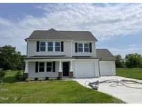 Charming two-story home featuring a two-car garage and well-manicured lawn at 186 Coharie Dr, Lillington, NC 27546