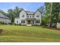 Beautiful new construction two-story home featuring a manicured lawn and a classic modern farmhouse design at 2040 Pleasant Forest Way, Wake Forest, NC 27587