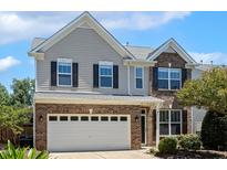 Charming two-story home with brick and vinyl siding, a two-car garage, and well-maintained landscaping at 2128 Feather Ridge Dr, Holly Springs, NC 27540