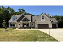Charming two-story home with a well-manicured lawn and a two-car garage at 217 Busterfield Ct, Benson, NC 27504