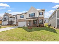 Charming two-story home with a well-manicured lawn, brick facade, and a welcoming front porch at 257 North Maple Walk Dr # 218, Garner, NC 27529