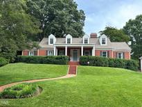 Charming red brick home with a lush green lawn and manicured hedges providing curb appeal at 2608 York Rd, Raleigh, NC 27608