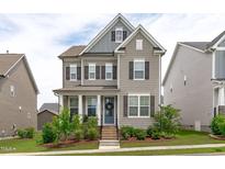 Charming two-story home with a well-maintained lawn and inviting front porch at 2915 Winter Crop Way, Apex, NC 27502
