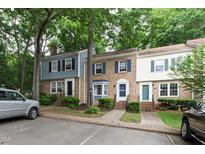 Charming townhouse with brick facade, blue shutters, and well-maintained landscaping in a treed community at 310 Bay Dr, Cary, NC 27511