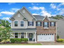 Two-story home boasts a brick and siding exterior, attached two car garage and manicured lawn at 3449 S Beaver Ln, Raleigh, NC 27604