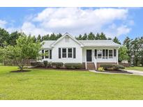 Charming single-story home with white siding, manicured lawn and mature landscaping at 366 E Smithfield St, Angier, NC 27501