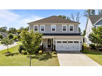 Charming two-story home with a gray exterior, a two-car garage, and a beautifully landscaped front yard at 408 Torwood Cir, Apex, NC 27523