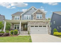 Charming two-story home featuring stone and siding accents, a two-car garage, and a welcoming front porch at 421 Gilpin Way, Cary, NC 27519