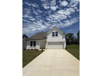 Charming two-story home with a well-manicured lawn and a long concrete driveway leading to the attached garage at 468 Winding Creek Dr Dr, Lillington, NC 27546