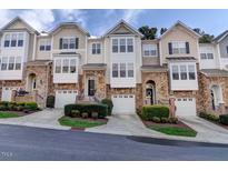 Inviting townhomes featuring stone accents, garages, manicured landscaping, and charming architectural details at 5113 Lady Of The Lake Dr, Raleigh, NC 27612