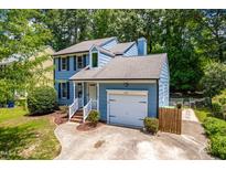 Charming two-story home boasts a well-manicured lawn, attached garage, and lovely curb appeal at 6104 New Market Way, Raleigh, NC 27609