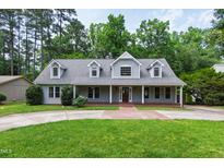 Charming gray two-story home featuring a welcoming front porch and well-manicured lawn at 7009 Brecken Ridge Ave, Raleigh, NC 27615