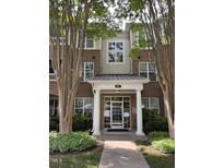Attractive brick building featuring a covered entrance with white columns and manicured landscaping at 8041 Allyns Landing Way Way # 303, Raleigh, NC 27615