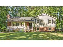 Charming two-story home with brick accents, green lawn, and covered front porch at 821 Stoneybrook Dr, Sanford, NC 27330