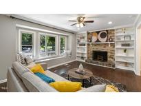 Cozy living room featuring a fireplace, built-in shelving, and a bay window with a window seat at 821 Stoneybrook Dr, Sanford, NC 27330