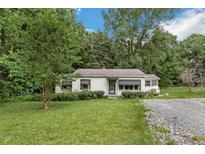 Quaint one-story home featuring a well-manicured lawn, mature trees, and a gravel driveway at 8635 Old Us 421 S, Bear Creek, NC 27207