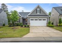 Charming one-story home featuring gray siding, a two-car garage, and well-maintained landscaping at 1010 Sandbar Ln, Durham, NC 27703