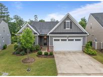 Charming single-story home with a well-manicured lawn, two car garage, and neutral gray siding at 1010 Sandbar Ln, Durham, NC 27703
