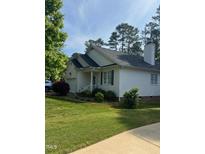 Charming single-story home with white siding, green shutters, well-maintained lawn, and attached garage on a sunny day at 103 Kylie Savannah Ct, Cary, NC 27511
