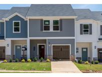 Charming two-story townhome featuring a garage, landscaped yard, and a welcoming front entrance at 1033 Winding Spring Dr, Mebane, NC 27302