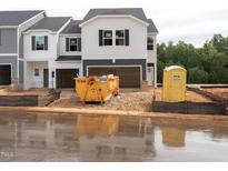 New two-story townhouse with a garage, situated in a residential community undergoing construction at 1037 Winding Spring Dr, Mebane, NC 27302