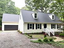 Charming home with white siding, black shutters, a gravel driveway, and beautiful landscaping at 108 W Marsha Gayle Ct, Fuquay Varina, NC 27526