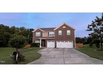 Charming two-story brick home featuring a two car garage, manicured lawn, and classic architectural details at 1116 Powder, Fuquay Varina, NC 27526