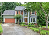 Charming two-story home featuring a well-manicured lawn, a brown garage door, and orange window shutters at 112 Hidden Bluff Ln, Cary, NC 27513