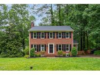 Charming brick two-story home with black shutters and a well-manicured lawn at 11816 Stannary Pl, Raleigh, NC 27613