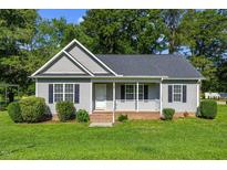 Charming single-story home with a well-manicured lawn, gray siding, black shutters, and a cozy front porch at 12449 W Pamlico St, Middlesex, NC 27557