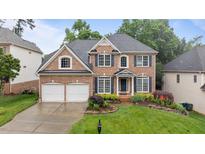 Charming two-story brick home with a well-manicured lawn and beautiful landscaping at 13121 Sargas St, Raleigh, NC 27614