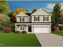 Charming two-story home with a well-manicured lawn and a two-car garage at 138 Jones Creek Ln, Lillington, NC 27546