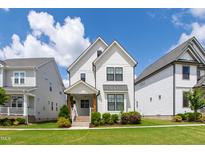 Beautiful two-story home featuring white siding, black-framed windows, and a well-manicured lawn on a sunny day at 248 Daniel Ridge Rd, Wendell, NC 27591