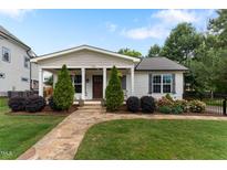 Charming single-story home featuring a stone walkway, manicured lawn, and delightful landscaping at 305 Georgetown Rd, Raleigh, NC 27608