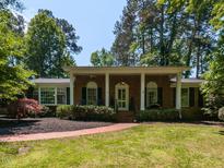 Charming brick home featuring a covered porch with white columns and a well-manicured front yard at 3421 Angus Rd, Durham, NC 27705
