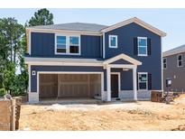 Two-story home showing blue siding, white trim, a large garage, and a covered front porch with stone accents at 3861 Rosebush Dr, Zebulon, NC 27597