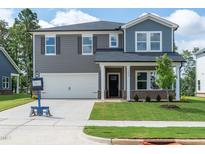 Charming two-story home with a two-car garage, well-maintained lawn, and inviting curb appeal at 3865 Rosebush Dr, Zebulon, NC 27597