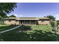 Charming brick home with a covered front porch and well-maintained lawn at 403 E Mcpherson Dr, Mebane, NC 27302