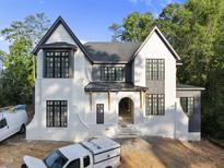 New construction exterior featuring white brick, black trim windows, covered entry and professional design at 5013 Coronado, Raleigh, NC 27609