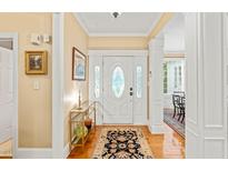 Inviting foyer with hardwood floors, decorative rug, and a leaded glass front door at 5405 Bluet Ct, Holly Springs, NC 27540