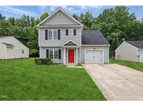 Charming two-story home featuring a well-manicured lawn, a bright red front door, and an attached one-car garage at 5408 Gunnette Dr, Raleigh, NC 27610