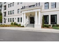 Stately white brick condo building entrance featuring columns and black framed windows at 620 Wade Ave # 505, Raleigh, NC 27605