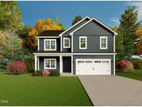 Charming two-story home with a well-maintained lawn, attached garage, and beautiful landscaping at 68 Mossy Bridge Ct, Lillington, NC 27546
