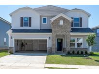 Charming two-story home featuring gray siding, brick accents, attached two-car garage, and a well-manicured lawn at 710 White Birch Ln, Angier, NC 27501