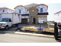 New construction home with brick accents and protective wrap, awaiting finishing touches at 710 White Birch Ln, Angier, NC 27501