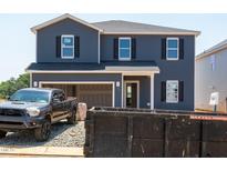 New construction two-story home featuring navy siding, black shutters, and an attached two-car garage at 722 White Birch Ln, Angier, NC 27501
