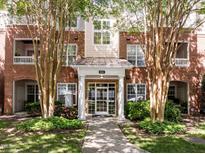 Beautiful brick building featuring manicured landscaping, multiple windows, and covered entryway at 8231 Allyns Landing Way # 101, Raleigh, NC 27615