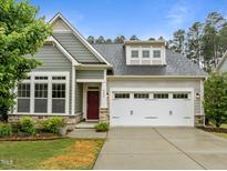 Charming home with a gray exterior, red front door, well-kept lawn, and two-car garage at 850 Apalachia Lake Dr, Fuquay Varina, NC 27526