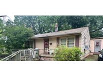 Quaint one-story home with a cozy front porch and mature landscaping at 1002 Loius St, Burlington, NC 27217